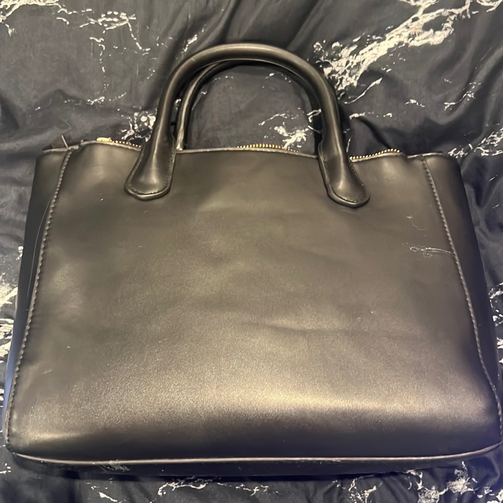Black purse has two zippers and one zipper on the inside. great space.